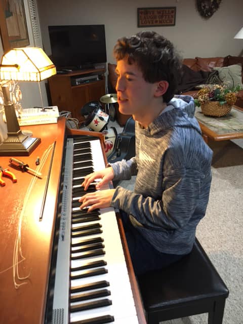 student plays the piano in his home at the 2021 Remote NJ Regional Braille Challenge