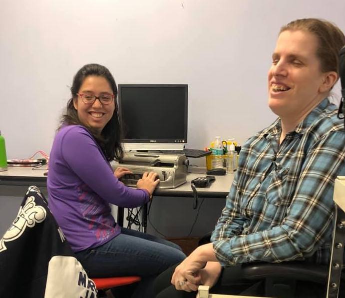 student and teacher sit together in front of the student's desk